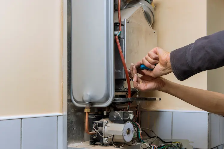 Tecnico che ripara un impianto di acqua calda a Fermo