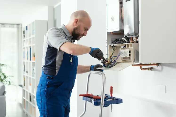 Tecnico che ripara una caldaia in una casa moderna a Forlì