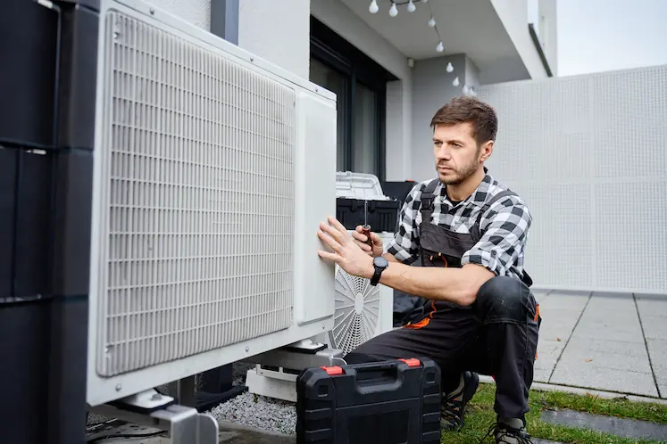 tecnico HVAC ripara l'unita esterna del condizionatore sul tetto in Emilia-Romagna