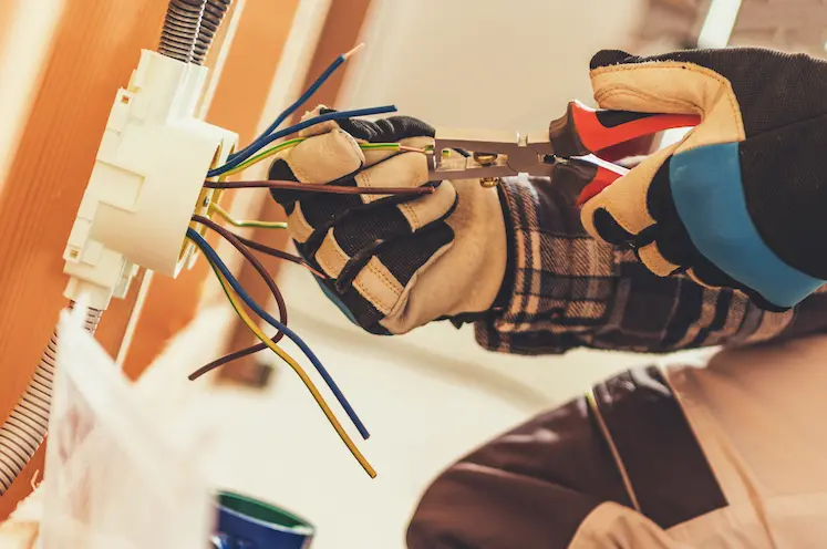 Elettricista a Chieti mentre installa una nuova presa elettrica a parete