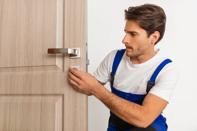 Tecnico che installa una nuova serratura sulla porta d'ingresso durante un intervento a Forlì