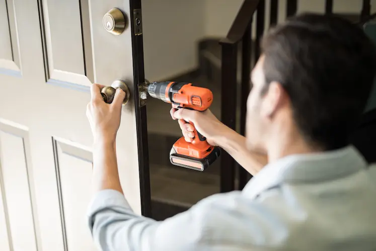 fabbro d'urgenza lavora sulla ferramenta della porta di casa in Piemonte